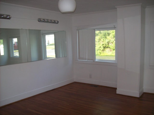 empty room featuring crown molding and dark wood-type flooring