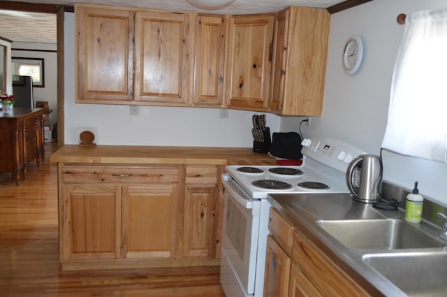 kitchen featuring white range with electric cooktop, a sink, and light wood-style flooring