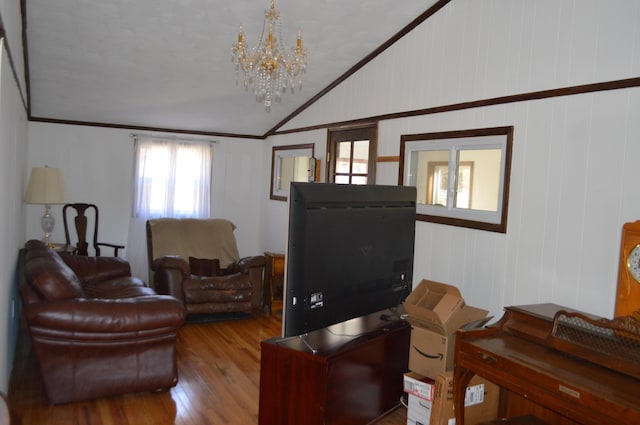 living room with lofted ceiling, an inviting chandelier, wood finished floors, and crown molding