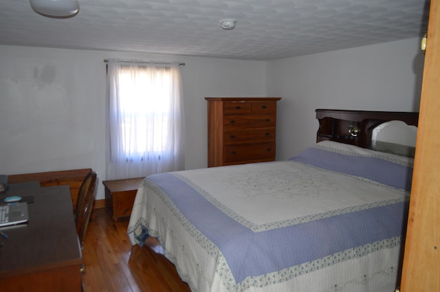 bedroom featuring a textured ceiling and hardwood / wood-style floors