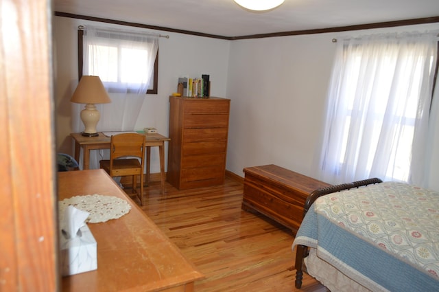 bedroom featuring ornamental molding, baseboards, and wood finished floors