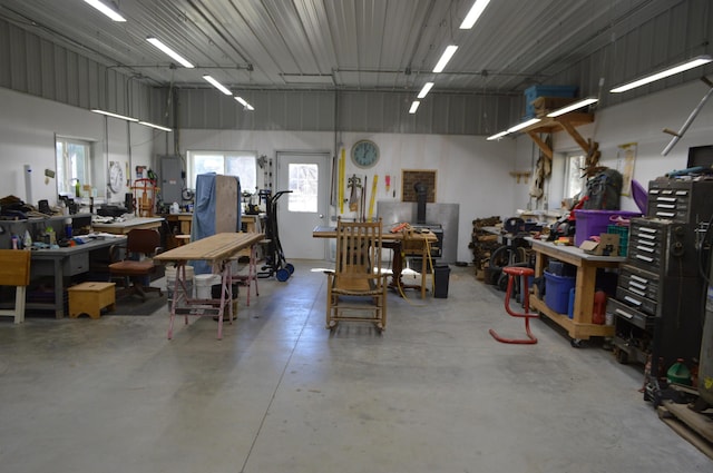 garage with electric panel, metal wall, and a workshop area