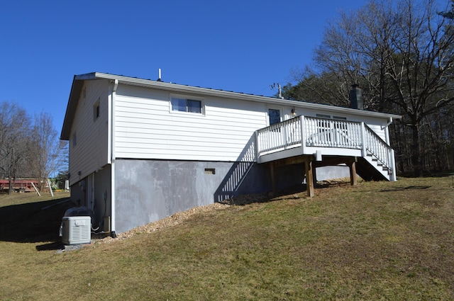 rear view of property with stairway, a deck, and a yard