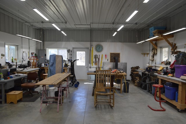 garage featuring a workshop area, metal wall, and electric panel