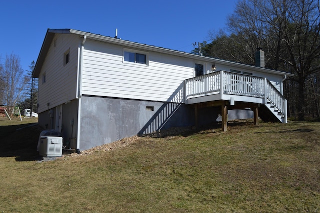 back of house with stairs, a lawn, and a wooden deck