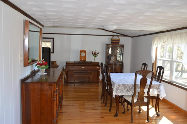 dining room featuring crown molding, baseboards, and light wood-style floors