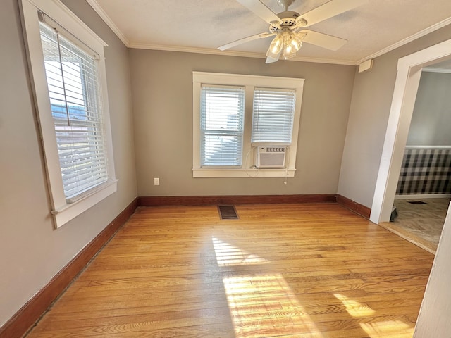 empty room with ornamental molding, a healthy amount of sunlight, and light hardwood / wood-style flooring