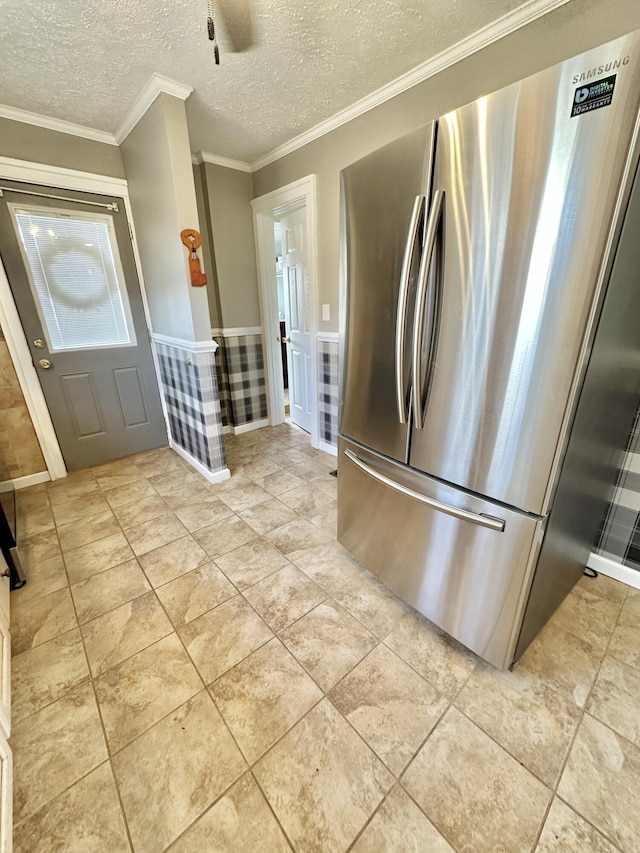 kitchen with crown molding, stainless steel fridge, and a textured ceiling