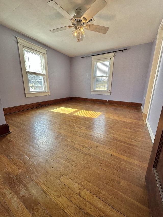 unfurnished room with ceiling fan, a healthy amount of sunlight, and light wood-type flooring