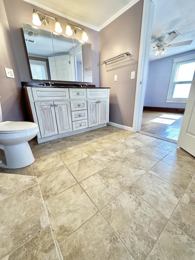 bathroom featuring ceiling fan, ornamental molding, vanity, and toilet