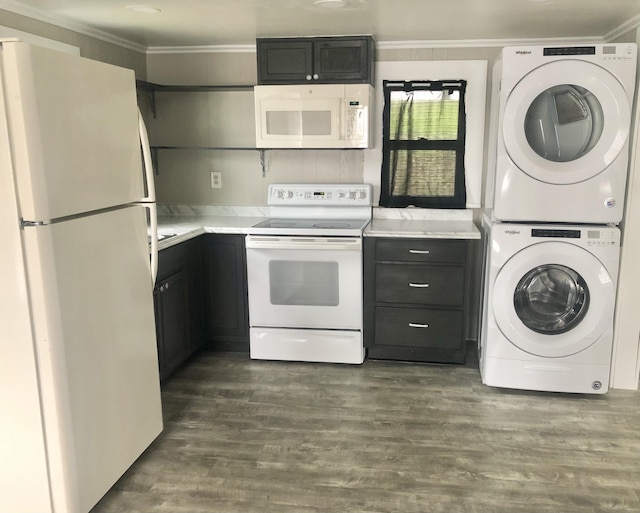 kitchen featuring white appliances, ornamental molding, stacked washing maching and dryer, and dark hardwood / wood-style flooring