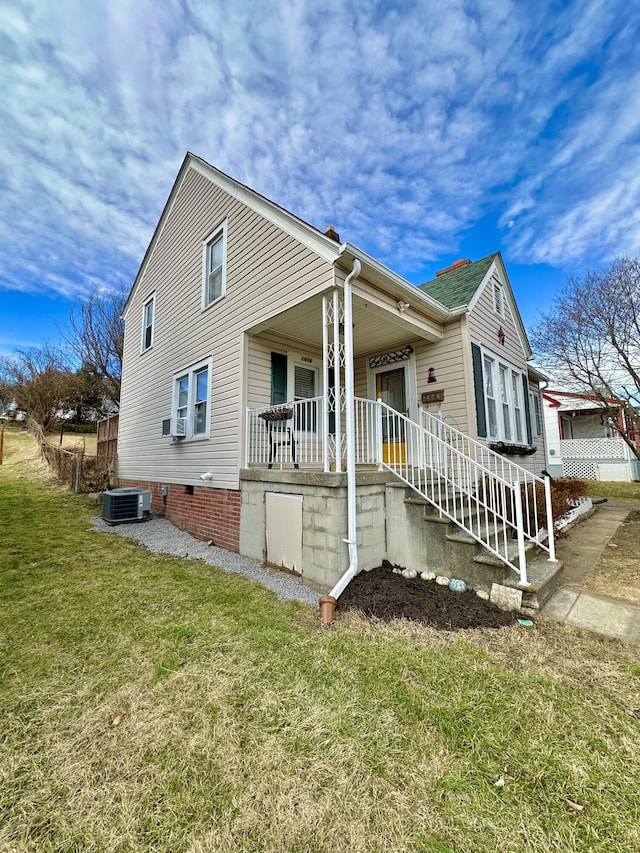 view of front of home featuring a porch, central AC, and a front yard