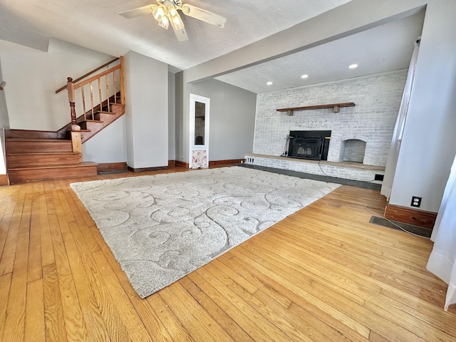 unfurnished living room with beam ceiling, ceiling fan, and light hardwood / wood-style floors