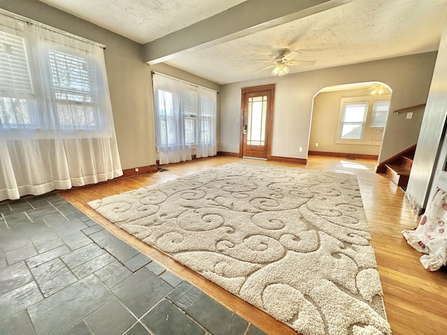 interior space featuring ceiling fan, dark wood-type flooring, and a textured ceiling