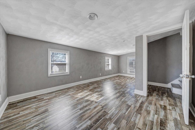 spare room featuring lofted ceiling and dark wood-type flooring