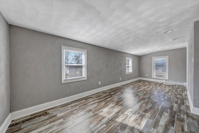 unfurnished room featuring lofted ceiling and hardwood / wood-style floors