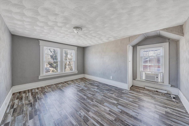 interior space featuring hardwood / wood-style floors, cooling unit, and a textured ceiling