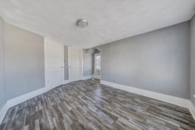 empty room with dark hardwood / wood-style flooring