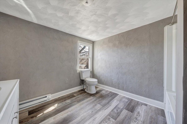 bathroom featuring a baseboard radiator, wood-type flooring, and toilet