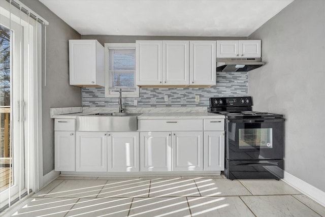 kitchen featuring sink, tasteful backsplash, light stone counters, white cabinets, and black / electric stove