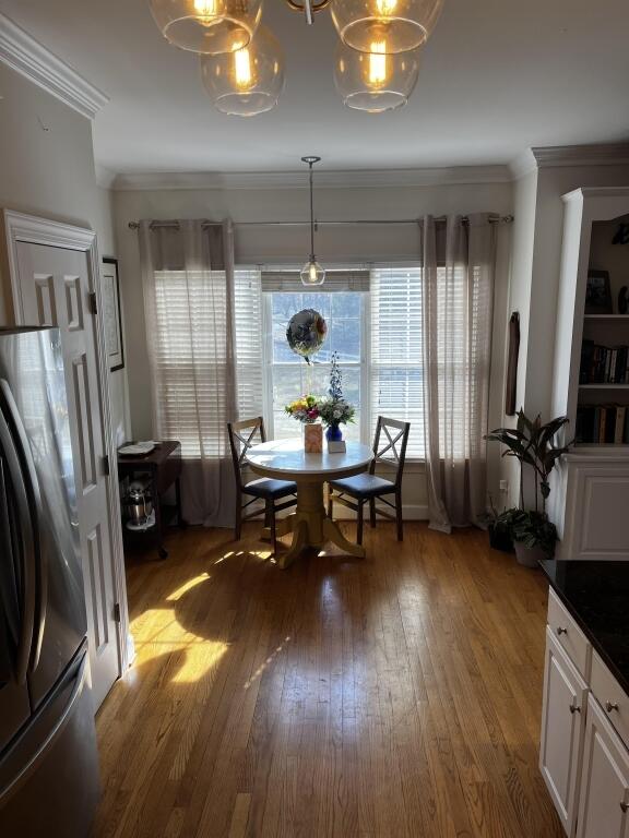 living room with light wood-style flooring, a ceiling fan, and crown molding