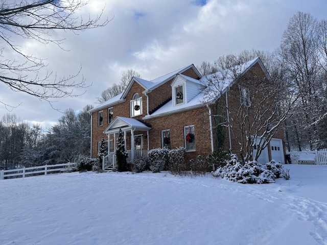 view of front facade featuring a garage, brick siding, and fence