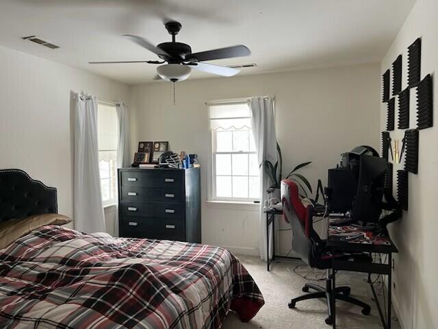 bedroom with carpet, visible vents, and ceiling fan