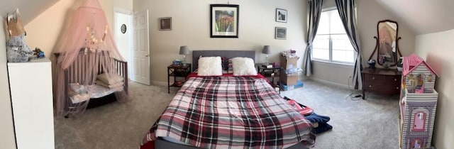 carpeted bedroom featuring vaulted ceiling and baseboards