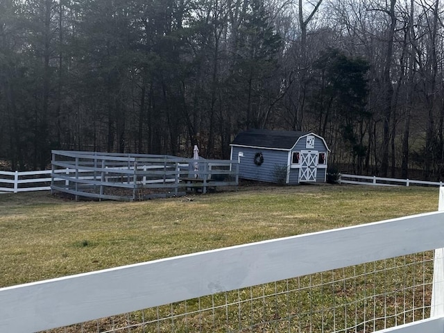 view of yard with a shed, fence, and an outdoor structure