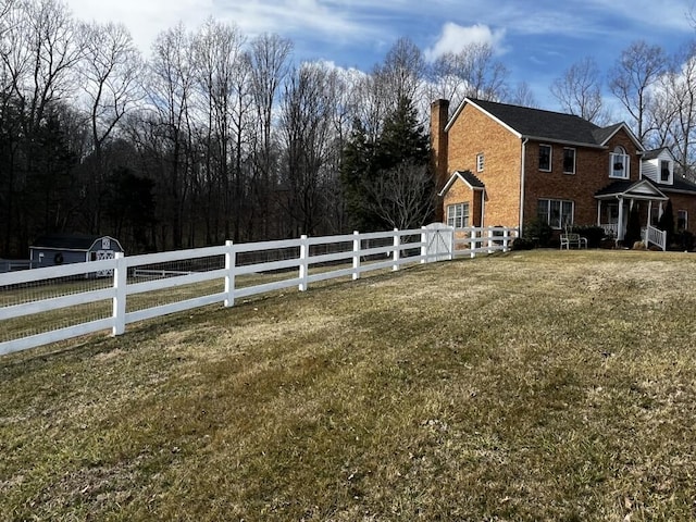 view of side of property featuring a yard, fence, and a chimney