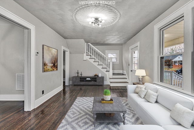 living room featuring visible vents, wood finished floors, a wealth of natural light, and stairway