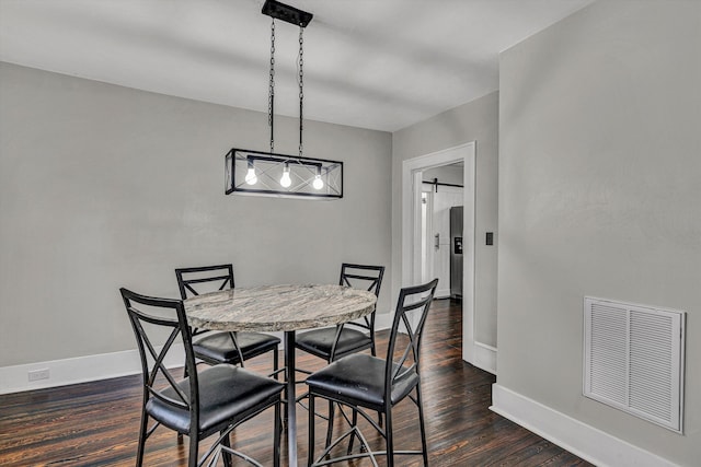 dining space with baseboards, visible vents, and dark wood finished floors