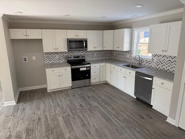 unfurnished bedroom featuring crown molding, multiple windows, baseboards, and dark wood-style flooring