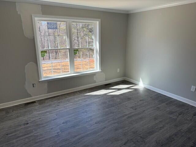 empty room with crown molding and dark hardwood / wood-style floors