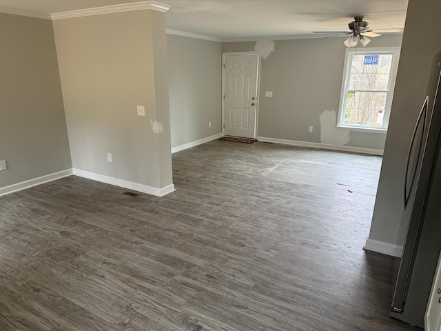 spare room with dark wood finished floors, a ceiling fan, and ornamental molding