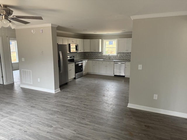 empty room featuring dark wood-style floors, ornamental molding, and baseboards