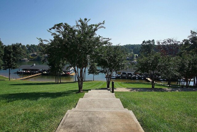 view of home's community featuring a water view and a lawn