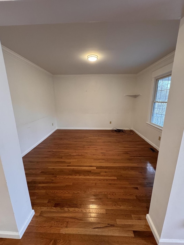 spare room featuring crown molding and dark hardwood / wood-style flooring