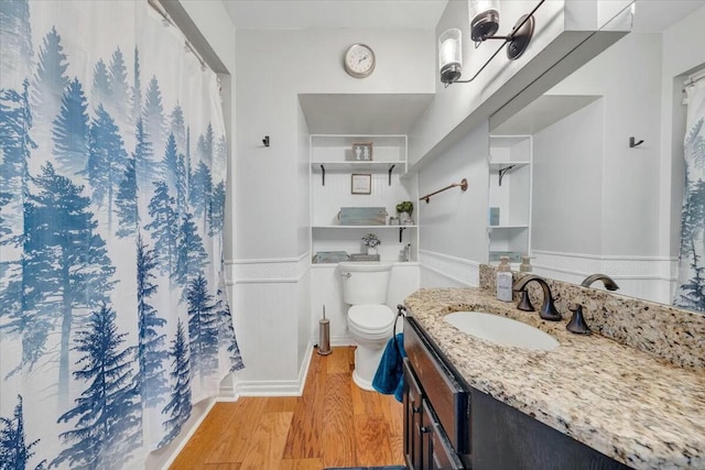 bathroom featuring wood-type flooring, toilet, and vanity