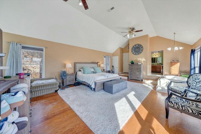 bedroom featuring ceiling fan with notable chandelier, high vaulted ceiling, and light wood-type flooring