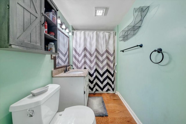 bathroom featuring toilet, hardwood / wood-style floors, vanity, and a shower with shower curtain