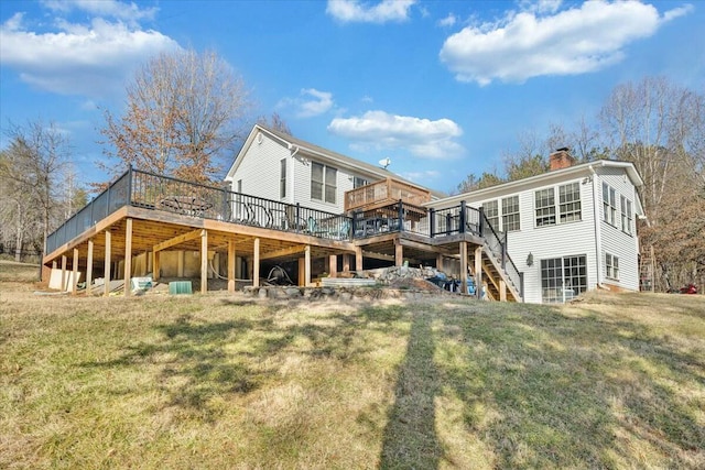 rear view of house featuring a wooden deck and a lawn