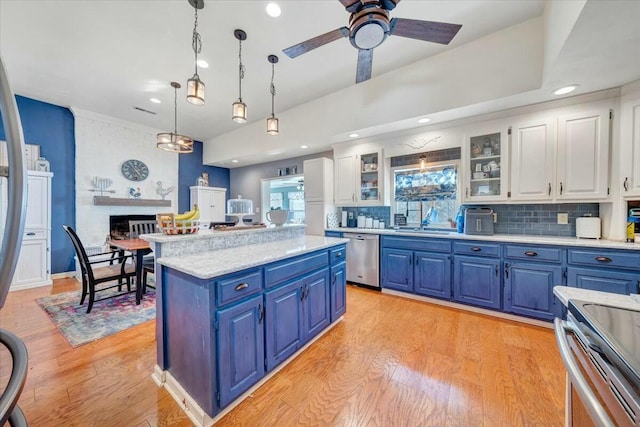 kitchen with appliances with stainless steel finishes, decorative light fixtures, blue cabinets, white cabinetry, and a center island