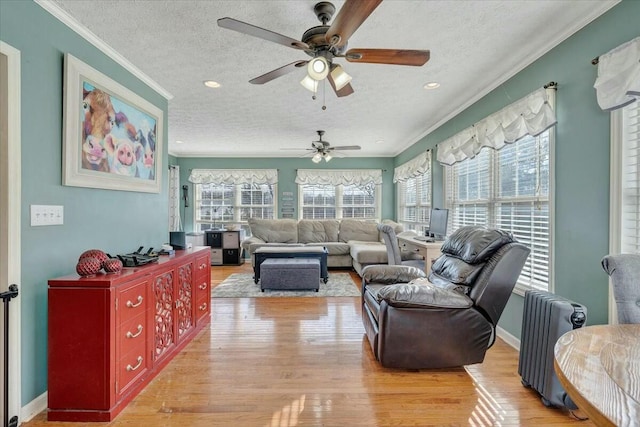 interior space featuring crown molding, a healthy amount of sunlight, radiator heating unit, and light wood-type flooring