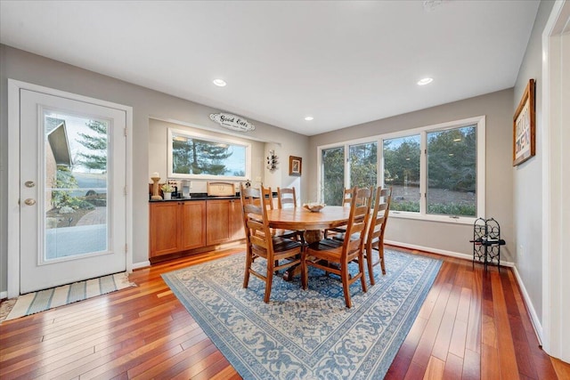 dining area with baseboards, plenty of natural light, and light wood finished floors