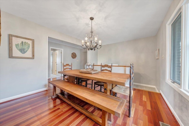 dining space featuring visible vents, baseboards, light wood-type flooring, and an inviting chandelier