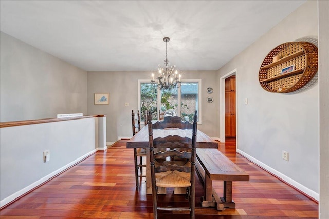 dining space featuring hardwood / wood-style flooring, baseboards, and a chandelier