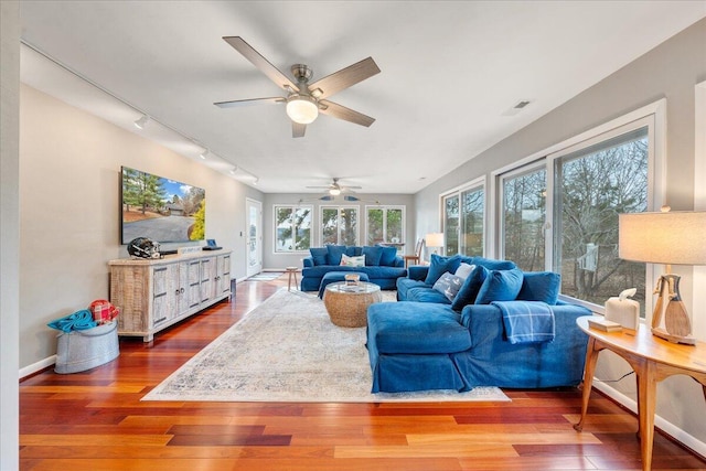 living room with ceiling fan, baseboards, hardwood / wood-style floors, and track lighting