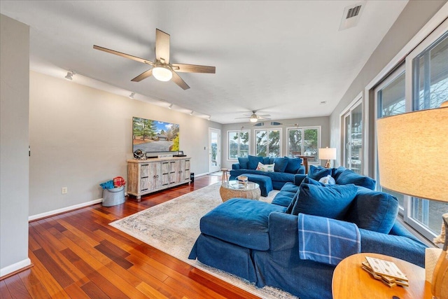 living area with a ceiling fan, baseboards, visible vents, hardwood / wood-style flooring, and rail lighting