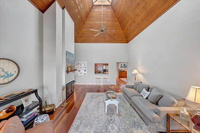 living room with a ceiling fan, wood finished floors, high vaulted ceiling, wood ceiling, and a large fireplace